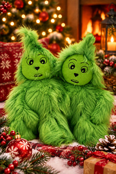 Two green furry Grinch-like plush toys with round faces and spiky hair, posed against a plain light background.
